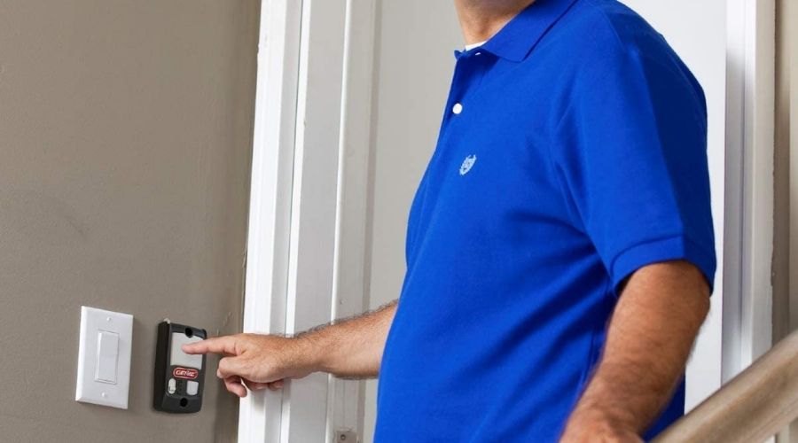 An image of a person using Genie Series II Garage Door Opener Wall Console, one of the best genie garage opener models