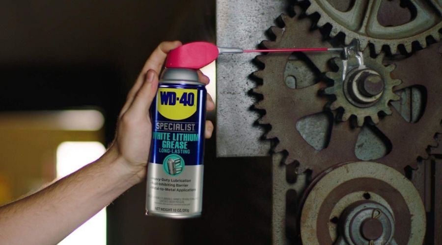 A person using WD40 300240 Specialist White Lithium Grease Spray, one of theBest garage door lubricant for Cold weather to lubricate the moving parts of the garage door opener 