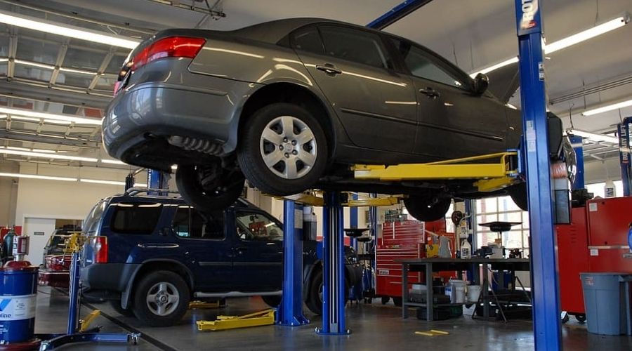 Can you put a car lift in a garage? The image shows a 4-post car lift used in a garage to lift a car