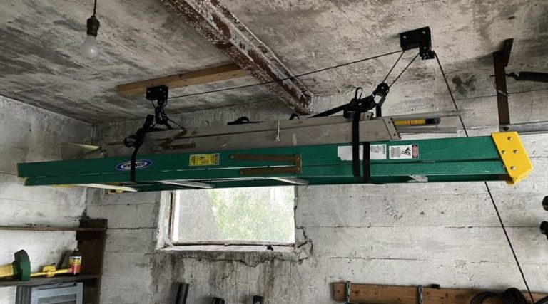 An image showing an extension ladder stored horizontally in the garage ceiling