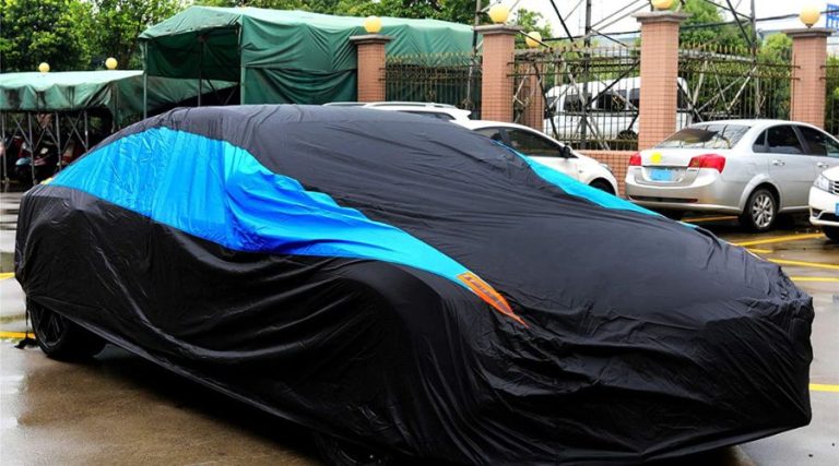 An image showing MORNYRAY Waterproof Car Cover All Weather Snowproof UV Protection Windproof Outdoor Full car Cover in use to store cars in the winter season