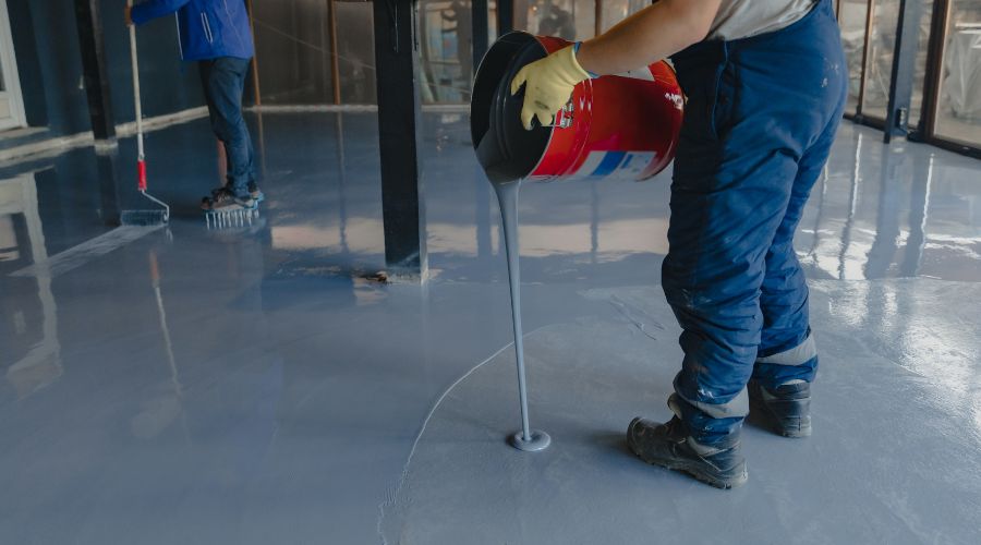 An image of an individual applying epoxy on garage floor. One of the best garage epoxy floor 